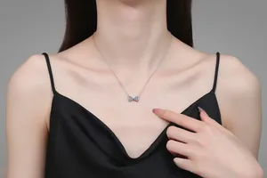 Détail du collier en argent s925 avec pendentif nœud étincelant sur modèle