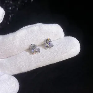 Three-stone cluster S925 sterling silver moissanite stud earrings on a gloved hand