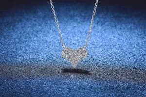 Dettaglio macro del ciondolo a cuore in argento con pavé di pietre di moissanite