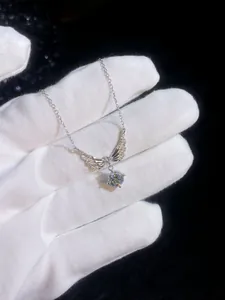 Macro shot of S925 silver angel wing pendant with shimmering round moissanite center