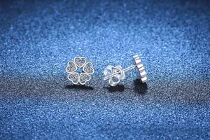 Dettaglio macro di orecchini a stella in argento S925 con cuori traforati e moissanite