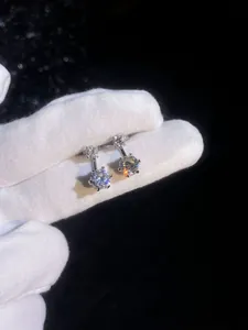 Macro di orecchini pendenti in argento sterling con doppia moissanite su fondo nero