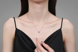 Gros plan d'un collier pendentif coeur en argent sterling S925 sur un mannequin femme