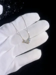 Macro view of heart-shaped moissanite pendant with shimmering pavé diamonds on silver chain