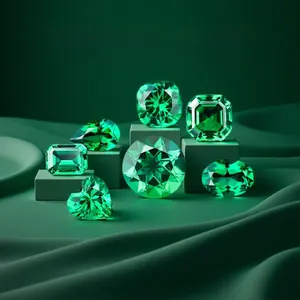 Macro display of seven lab-grown emerald gemstones in various cuts on silk background