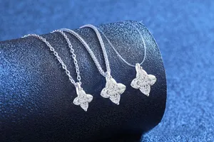 Detailed macro view of S925 sterling silver four-leaf flower pendants with moissanite crystals
