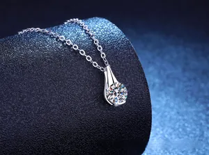 Vista macro di una collana con ciondolo in argento a goccia e pietra di moissanite tonda