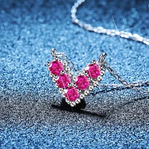 925 silver V-shaped heart necklace with pink gemstones on dark textured background