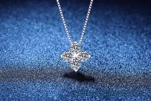 Detailed close-up of a silver four-leaf clover necklace with D-color moissanite stones