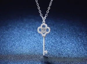 Macro d'un collier clé en argent S925 avec moissanite sur un fond bleu profond brillant