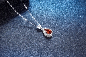 Gros plan du collier en argent S925 avec rubis taille poire et micro-pavage de diamants