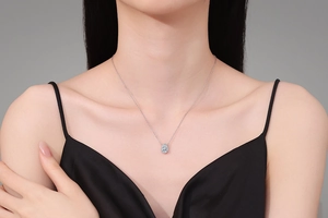 Close-up of S925 silver pear-cut gemstone necklace worn on a black silk dress