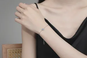 Dettaglio del bracciale in argento S925 con moissanite al polso con ciondolo tondo fine