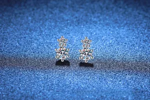 Macro shot of double moissanite silver stud earrings with snowflake prong setting