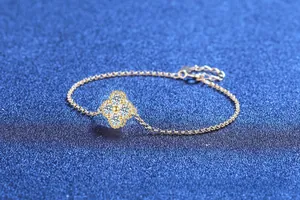 Macro view of four-leaf clover bracelet featuring pavé-set stones and gold-plated finish