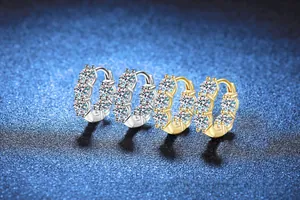 Détail de créoles en moissanite de 4 carats en finition argent et or sur fond bleu