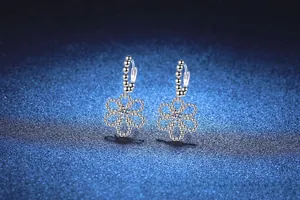 Detailed macro view of S925 sterling silver five-petal flower earrings with D color moissanite