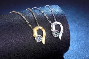Gros plan de pendentifs en argent et or avec moissanite brillante et design en cœur