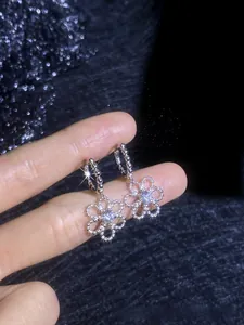 Close-up of S925 sterling silver camellia flower earrings with sparkling D color moissanite