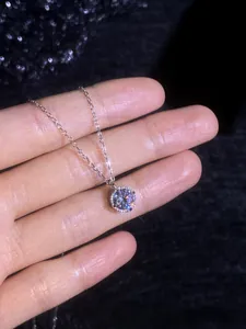 Détail macro du pendentif en moissanite étincelant avec serti à quatre griffes et chaîne fine