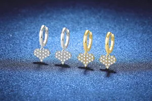 Macro detail of silver and gold heart hoop earrings with pavé set sparkling stones