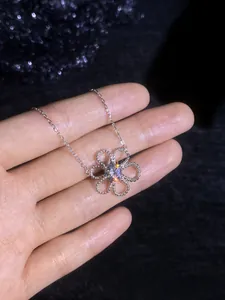 Macro detail of S925 silver necklace featuring a floral pendant with sparkling moissanite