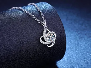 Macro view of clover pendant with round cut center stone and micro-pave diamonds
