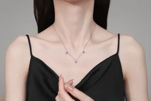 Detail of S925 silver necklace featuring three blue moissanite stones on a female model
