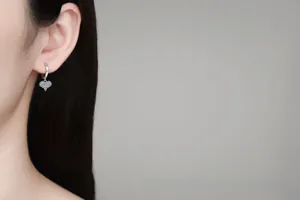 Close-up of a model wearing sparkling heart-shaped moissanite silver earrings for women