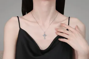 Close-up of S925 sterling silver cross necklace with moissanite stones on a female model