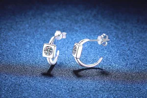 Macro detail of S925 sterling silver C-shape earrings with square set moissanite stones