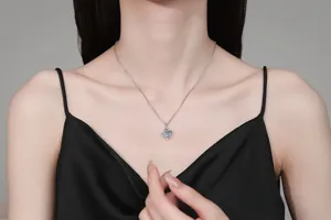 Close-up of a silver S925 four-leaf clover pendant with sparkling moissanite on a model