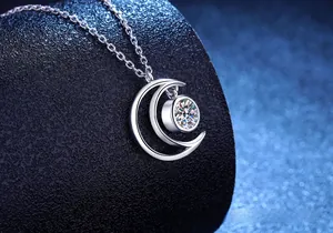 Macro detail of S925 sterling silver moon necklace with 0.5ct moissanite on black stand
