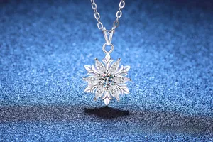 Macro shot of silver snowflake pendant with moissanite on blue glitter background