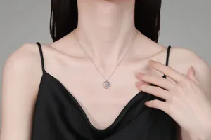 Close-up of S925 sterling silver moon pendant necklace with blue moissanite on model