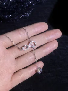 Detailed close-up of 925 sterling silver infinity pendant with moissanite tassel drop