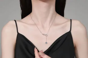 S925 sterling silver infinity pendant necklace with light blue stone on a female model