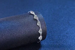 Detail of silver heart-shaped moissanite bracelet with five brilliant cut stones