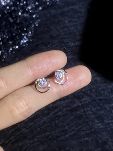 Macro view of S925 sterling silver moissanite stud earrings held for detail showcase