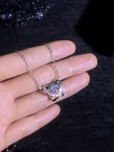 Macro view of Saturn pendant necklace with sparkling stone on hand display