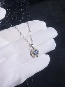 Nahaufnahme der S925 Silberkette mit funkelndem meerblauem Moissanit-Herzanhänger