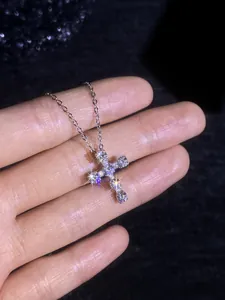 Close-up of S925 sterling silver cross pendant featuring sparkling moissanite stones