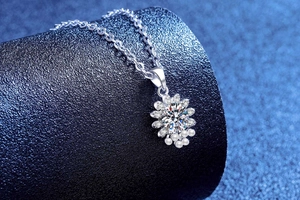 Detailed view of S925 silver sunflower pendant with moissanite and pearls on display