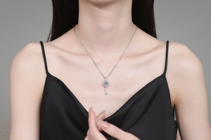 Close-up of sparkling moissanite key pendant in S925 sterling silver on a female model
