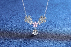 Macro view of sterling silver flower necklace with pink and clear marquise moissanite