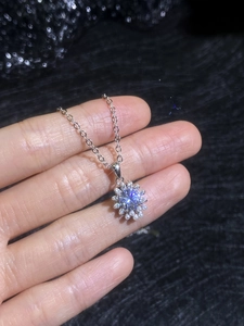 Macro shot of a flower-shaped S925 silver pendant with moissanite and mini shell pearls