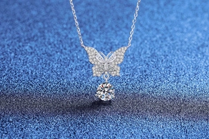 Macro view of sterling silver bow necklace with sparkling moissanite butterfly pendant