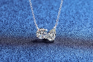 Macro shot of S925 silver necklace with pear and round moissanite pendant detail