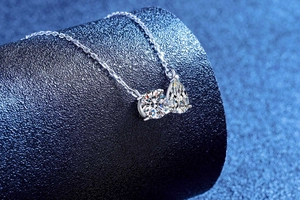 Close-up of S925 silver necklace with sparkling round and pear-cut moissanite charms