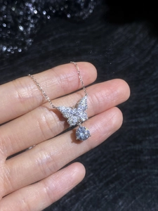 Macro shot of S925 sterling silver bow pendant necklace with sparkling pavé moissanite